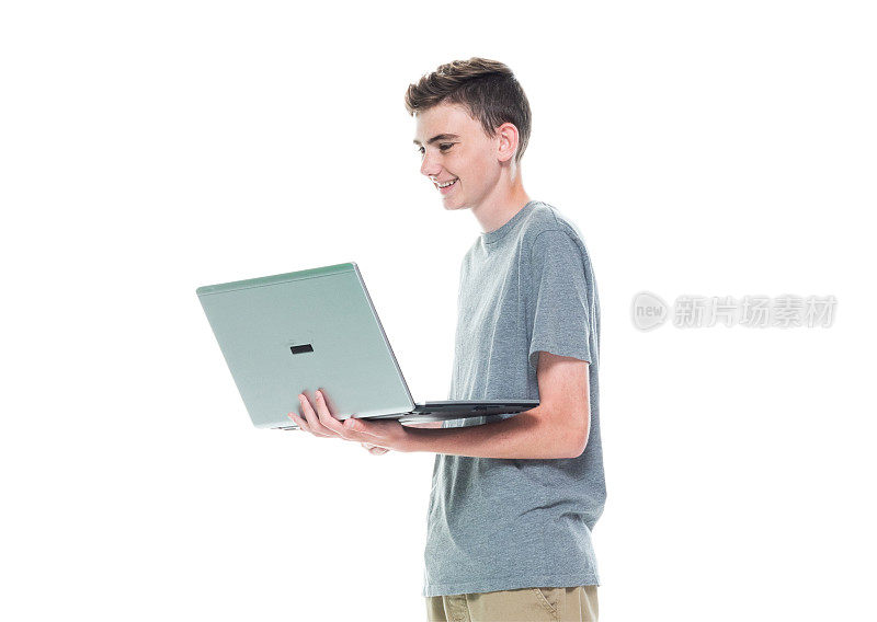 俯视/全身/一个人/一个十几岁的男孩只有12-13岁英俊的人白人男性/年轻男子男孩/十几岁的男孩在白人背景下工作和使用笔记本电脑/电脑
